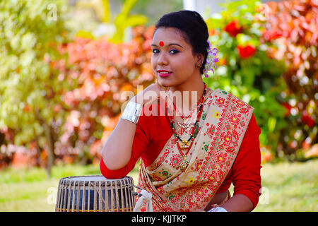 Assamesisch Mädchen in traditioneller Kleidung mit einem Dhol (Trommel), Pune, Maharashtra posieren. Stockfoto