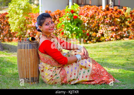 Assamesisch Mädchen in traditioneller Kleidung mit einem Dhol (Trommel), Pune, Maharashtra posieren. Stockfoto