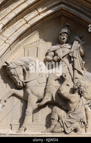 Die katholische Kirche St. Martin, Villers sur Mer, Frankreich. Tympanon Detail: St. Martin geben die Hälfte oh seinen Mantel zu ein Armer. Stockfoto