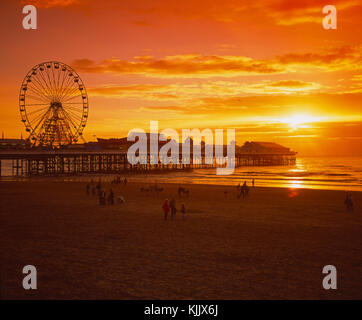 Sonnenuntergang über dem Sand und Central Pier in Blackpool, mit dem großen Rad silhouetted, Blackpool, Lancashire, England Stockfoto