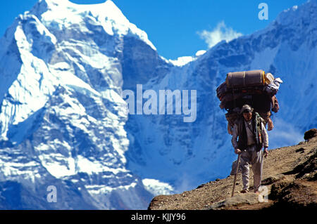 Sherpa Tragetaschen auf Everest Trail. Nepal. Stockfoto