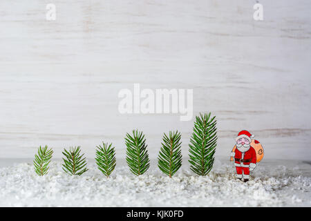 Hintergrund des neuen Jahres. Die Zahlen von Santa Claus und Hirsche. Billet für Postkarten oder herzlichen Glückwunsch. Tannen im Wald unter den schneewehen. kopieren. Stockfoto