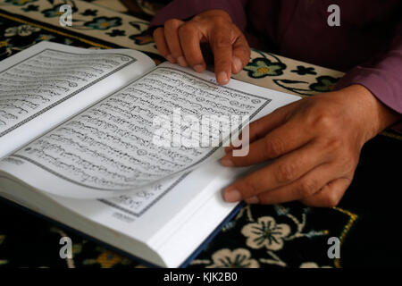 Saigon Zentralmoschee. Muslimischen mann Lesen eines arabischen Koran oder Koran. Close-up. Ho Chi Minh City. Vietnam. Stockfoto