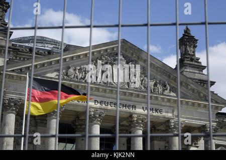 Reichstagsgebäude und deutsche Flagge durch einen Zaun gesehen, 21.05.2017. Das Reichstagsgebäude am Platz der Republik in Berlin-Tiergarten ist seit 1999 Sitz des Deutschen Bundestages. Das zwischen 1884 und 1894 von Paul Wallot errichtete Gebäude beherbergte den Reichstag des Deutschen Reiches sowie den Reichstag der Weimarer Republik. Nach schweren Schäden beim Reichstagsbrand von 1933 und im Zweiten Weltkrieg wurde das Gebäude in den 1960er Jahren in modernisierter Form rekonstruiert und von 1991 bis 1999 neu gestaltet. - KEIN KABELSERVICE - Foto: Sascha Steinach/dpa-Zentralbild/dpa | Stockfoto