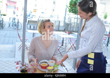 Kellnerin das Essen im Cafe mit Stockfoto