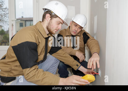 Bauherren mit einem gelben Multimeter Haus zu kalibrieren Stockfoto