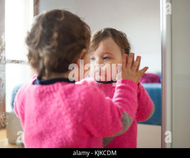 Kleinkind Baby Mädchen spielen mit Spiegel im Schlafzimmer. Stockfoto