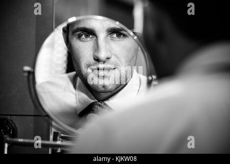 Junger Mann bei sich selbst in einem Spiegel sehen. Frankreich. Stockfoto