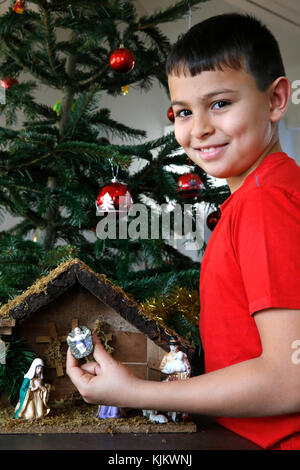 10-Year-Old Boy Verlegung eine Weihnachtskrippe. Frankreich. Stockfoto