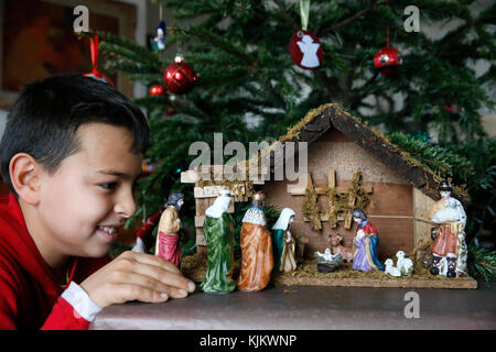 10-Year-Old Boy Verlegung eine Weihnachtskrippe. Frankreich. Stockfoto