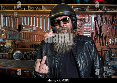 Motorradfreak in seiner Werkstatt Stockfoto