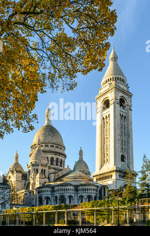 Die Basilika des Heiligen Herzen von Paris bei Sonnenaufgang im Herbst von drei-viertel hinten mit dem quadratischen Turm und Zweige in der foregrou Stockfoto