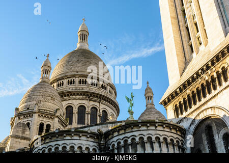 Rückansicht der Kuppel der Basilika der Heiligen Herzen von Paris bei Sonnenaufgang mit dem quadratischen Turm im Vordergrund. Stockfoto