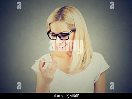 Frau Brille mit einem smart phone Funktion Spracherkennung online auf grauen Hintergrund isoliert Stockfoto