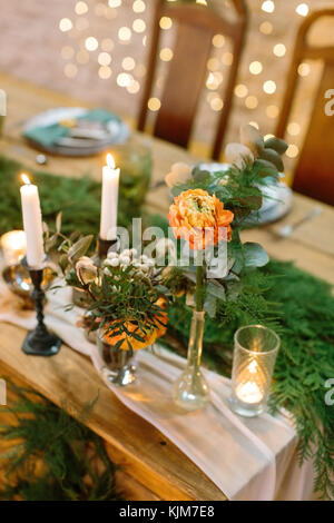 Dekoration, Blumen, Hochzeit Konzept. aus der Nähe von bafingly schöne Blume orange Farbe, die in groß und schlank Vase auf der Ecke der Tabelle platziert ist für Brautpaare serviert. Stockfoto