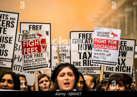 Studenten schwenken Plakate bei der Protestdemonstration für die Kampagne gegen Bildungsgebühren und -Kürzungen durch die Straßen Londons. Stockfoto