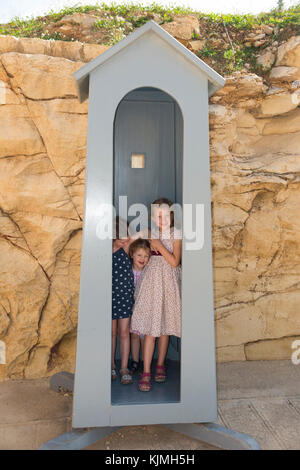 Drei Kind/Kinder Touristen spielen in der fiktiven "Sentry box" auf dem Weg zum Fort Rinella und Rinella Battery, Kalkara, Malta. (91) Stockfoto