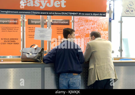 2 Unternehmer Passagieren mit Handgepäck auf der easyJet Ticket Verkauf stand im Terminal 3 Stockfoto