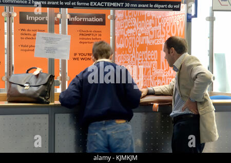 2 Unternehmer Passagieren mit Handgepäck auf der easyJet Ticket Verkauf stand im Terminal 3 Stockfoto