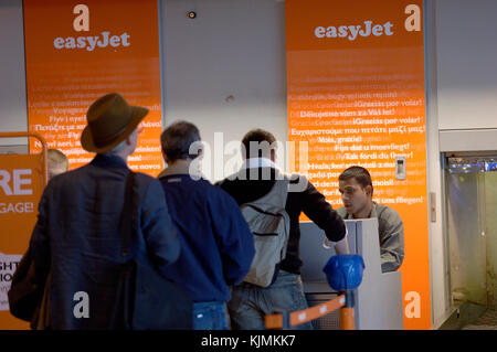 EasyJet Check-in Warteschlange mit Geschäftsleuten in Anzügen mit Handgepäck Stockfoto