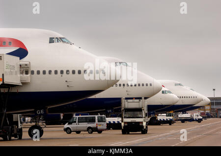 Besetzt die Luftseite Straßenverkehr, Begleitfahrzeuge und eine Reihe von British Airways airliner Nasen auf einem grauen bewölkten Tag. Stockfoto