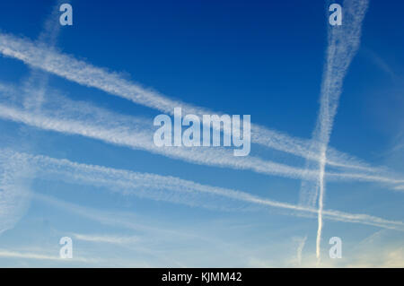 Mehrere Kreuzung Kondensstreifen über einen blauen Himmel im Süden Londons. Stockfoto