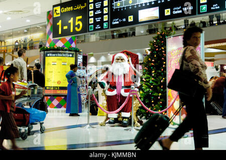 Die Passagiere der Sheikh Rashid Terminal Duty-free-Shopping area santa Weihnachtsmann, Weihnachtsbaum und Dekorationen Stockfoto