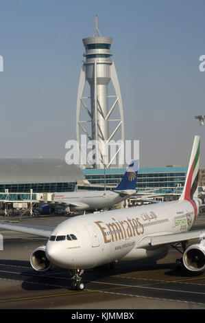 Emirates A330 rollt hinter ein Egypt Air A330-200 mit Control-Tower hinter Stockfoto