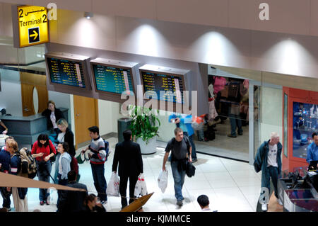 Passagiere mit Handgepäck in der Sheikh Rashid Terminal Duty-free-Shopping Bereich Eingang/Ausgang Zeichen an Klemme 2 Stockfoto