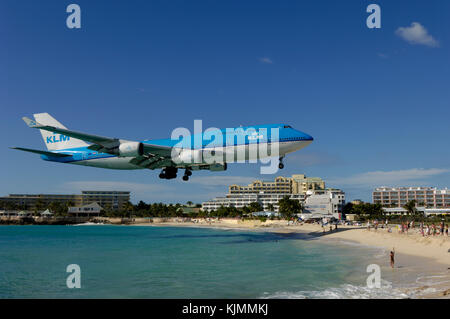 Flying Low auf Final-Ansatz Landung über Maho Beach mit Hotels hinter B747 auf der Landebahn mit Hügeln hinter Stockfoto