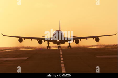 Ein Verkehrsflugzeug, die in der Abenddämmerung von der Start- und Landebahn am Flughafen, Sint Maarten in Niederländische Antillies. Rauchen Motoren. Stockfoto