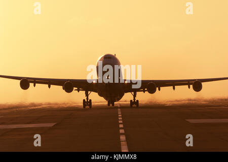 Ein Verkehrsflugzeug, die in der Abenddämmerung von der Landebahn von Sint Maarten Flughafen, in dem niederländischen Antillies. Rauchen Motoren. Stockfoto