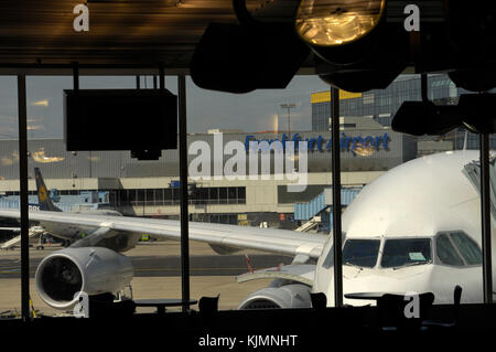 Windschutzscheibe der South African Airways Airbus A340 zu einem Tor und Lufthansa Boeing 737 hinter am Terminal durch ein Fenster gesehen geparkt abgestellt Stockfoto