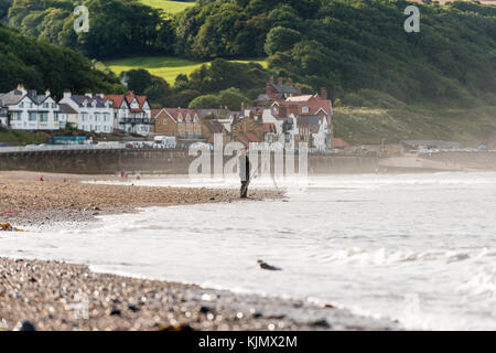 Ein Mann, der am Strand von Sandsend, whitby, großbritannien, angeln wird Stockfoto