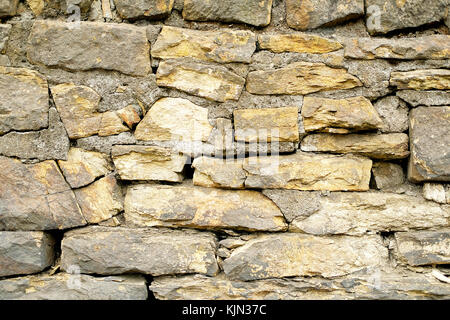 Vollbilderansicht der handgefertigten Wand aus ungeraden geformten Felsen gebaut. Stockfoto