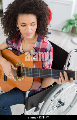 Behinderte Mädchen spielte Gitarre Stockfoto