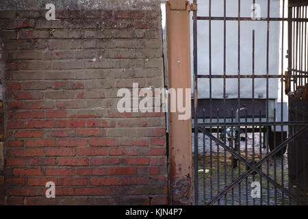 Eine verrostete Eisentor auf einem wackeligen Wand. Stockfoto