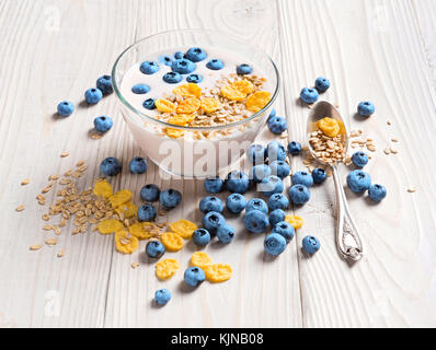 Schüssel mit hausgemachtem Joghurt mit Müsli und frischen Heidelbeeren auf Holztisch. frischen Joghurt. gesunde Ernährung Konzept. hohe Auflösung Produkt. Stockfoto