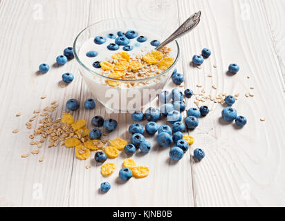 Schüssel mit hausgemachtem Joghurt mit Müsli und frischen Heidelbeeren auf Holztisch. frischen Joghurt. gesunde Ernährung Konzept. hohe Auflösung Produkt. Stockfoto