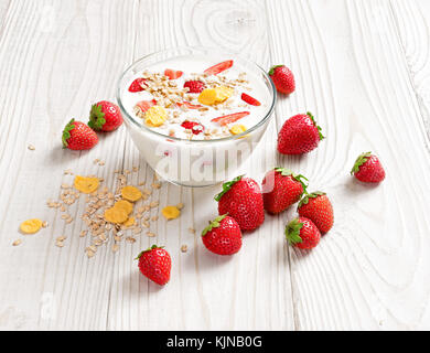 Schüssel mit hausgemachtem Joghurt mit Müsli und frische Erdbeeren auf Holztisch. frischen Joghurt. gesunde Ernährung Konzept. hohe Auflösung Produkt. Stockfoto