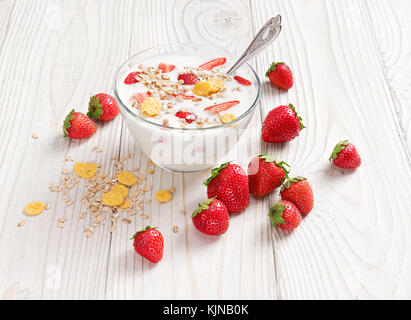 Schüssel mit hausgemachtem Joghurt mit Müsli und frische Erdbeeren auf Holztisch. frischen Joghurt. gesunde Ernährung Konzept. hohe Auflösung Produkt. Stockfoto