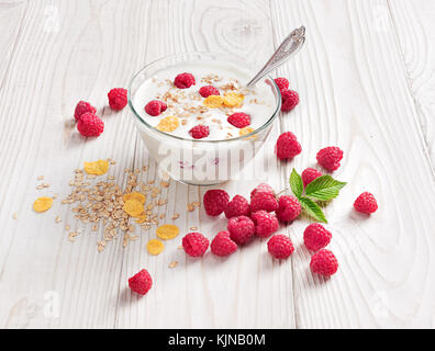 Schüssel mit hausgemachtem Joghurt mit Müsli und frischen Himbeeren auf Holztisch. frischen Joghurt. gesunde Ernährung Konzept. hohe Auflösung Produkt. Stockfoto