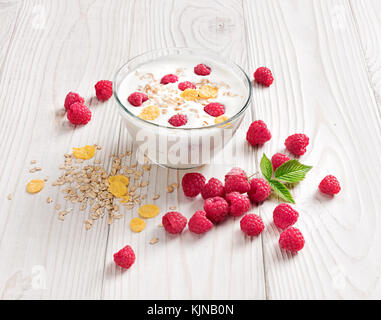 Schüssel mit hausgemachtem Joghurt mit Müsli und frischen Himbeeren auf Holztisch. frischen Joghurt. gesunde Ernährung Konzept. hohe Auflösung Produkt. Stockfoto