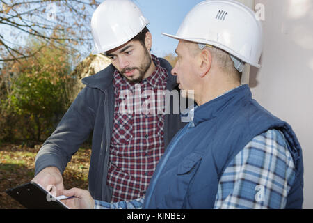 Handwerker hardhats tragen in der Diskussion Stockfoto