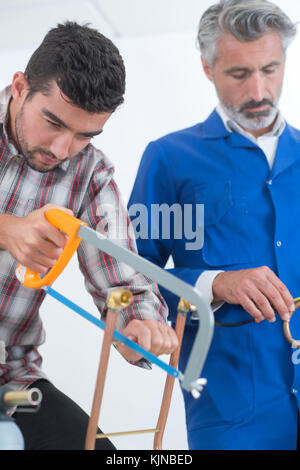 Man Schneiden von Metall Rohr Hand sah Stockfoto