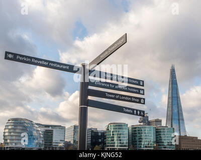 Wegweiser zu den wichtigsten Attraktionen in der Nähe von Tower Hill in London mit modernen Gebäuden Hintergrund, einschließlich der Shard Stockfoto