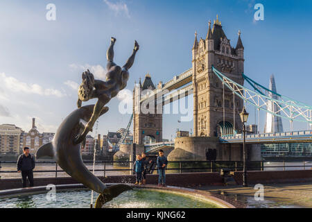 Gegenüberstellung von David wynne Mädchen mit einem Delphin Statue in der Nähe der Tower Bridge in London - victorian Engineering auf der Themse Stockfoto