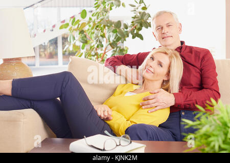 Geschossen von einem älteren Ehepaar einander umarmen, während zu Hause entspannen. Stockfoto