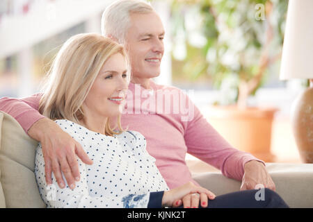 Geschossen von einem älteren Ehepaar einander umarmen, während zu Hause entspannen. Stockfoto