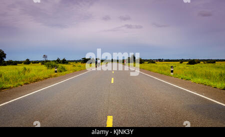 Endlose Autobahn durch die Uganda Landschaft mit ein paar Biker mit kopieren. Dies ist die Straße zwischen Mbale und soroti und hat durch Ch. Stockfoto